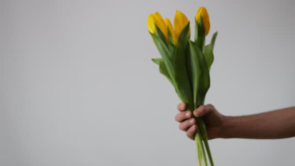 Счастливчик Протягивает Букет Цветов Камере Улыбается Букет Желтых Тюльпанов — стоковое видео