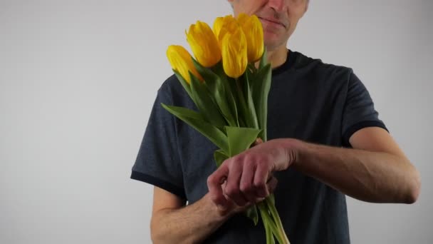 Bir Adam Kameraya Bir Buket Çiçek Uzatıp Gülümsüyor Sarı Lale — Stok video