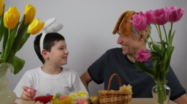 Paskalya tavşanının kulaklarında komik bir çocuk. Tavşan kulaklı baba oğul. 4K