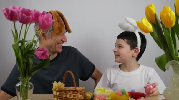 复活节兔子的耳朵里有个有趣的男孩父子俩在兔子耳朵里画鸡蛋 — 图库视频影像