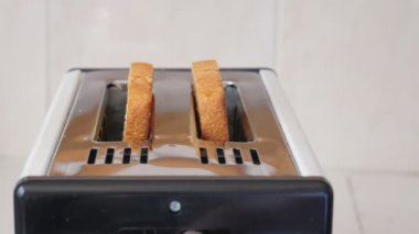 Bir tost makinesi kahvaltıda yakın plan tost ekmeği yapar. Tost makinesinden fırlamış tost ekmeği. Taze kahvaltı. 4K