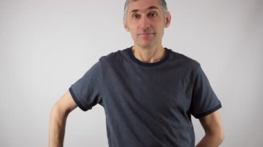 Bir adam sarı lale buketi tutuyor. Gülümsüyor. Adamın saçı ağarmış. Neşeli duygular. Lale tutan yakışıklı, gri saçlı adam. 4K.
