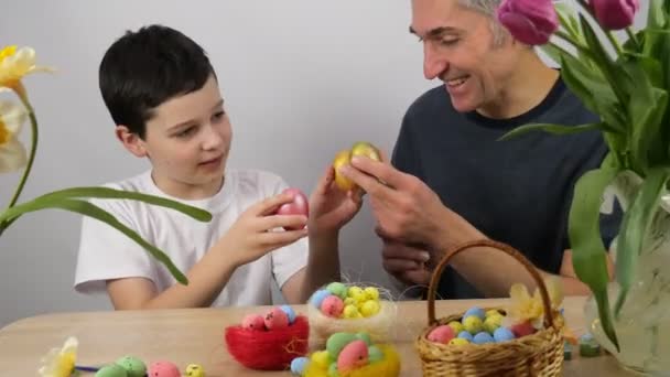 复活节的家庭游戏 爸爸和儿子在画鸡蛋 准备复活节 郁金香和彩蛋4K — 图库视频影像