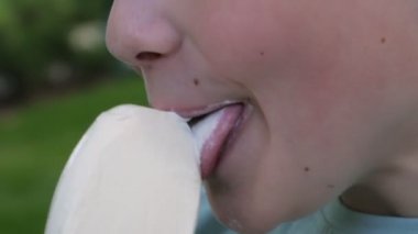Dondurma yiyen gülümseyen çocuk. Çocuk dondurma yalıyor. Yüze yakın çekim. Dondurma reklamı. 4K