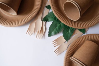 Eko kağıt sofra takımı. Beyaz arka planda eko plakalar. Geri dönüşüm kavramı çevre dostudur. Ağacın yeşil yaprağı. Boşluğu kopyala