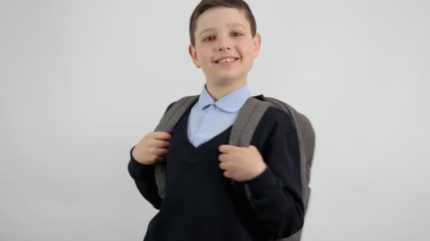 Szczęśliwy Chłopak Szkolnych Ciuchach Plecakiem Plecami Uśmiecha Się Kamery Białym — Wideo stockowe