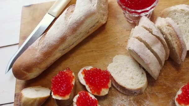 Butyrbrody com caviar vermelho. baguete picada e caviar vermelho em um butyrboard — Vídeo de Stock