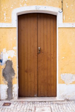 Portekiz'de yer yıpranmış ve hırpalanmış eski sarı kapı