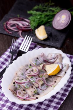 Ringa balığı salatası soğan ve otlar ve limon ile