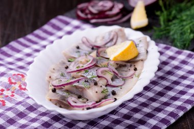 Ringa balığı salatası soğan ve otlar ve limon ile