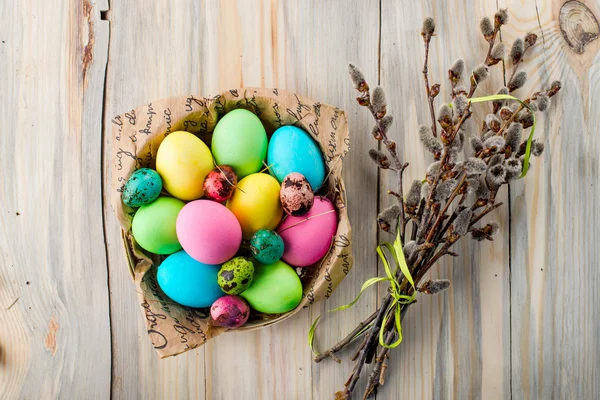 Ovos de Páscoa coloridos na cesta com ramos de salgueiro — Fotografia de Stock