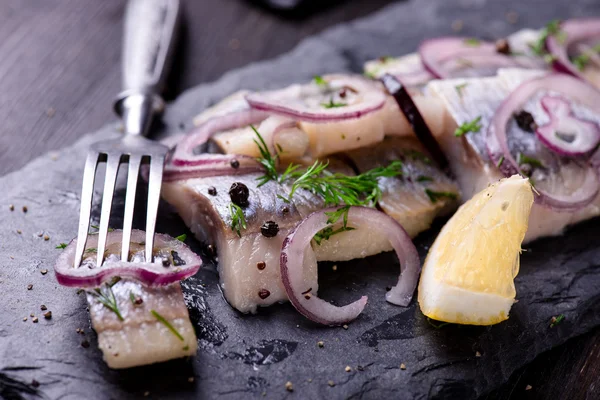 Sliced herring on a black slate plate Royalty Free Stock Images