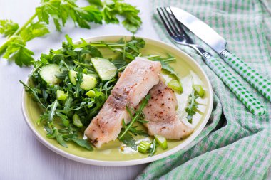 Baharatlı sos ve salata ile balık buğulama dilim