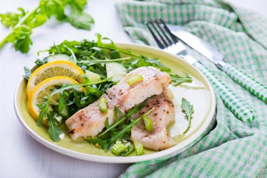 Baharatlı sos ve salata ile balık buğulama dilim