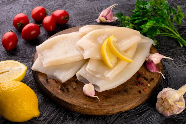 Preparation of raw squid and ingredients on board Stock Image