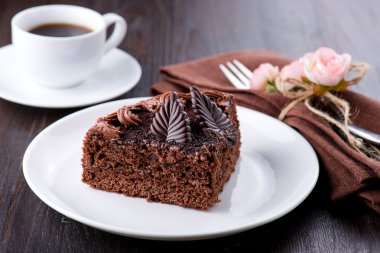 Plaka üzerinde kahve ile lezzetli çikolatalı kek. Koyu arka plan