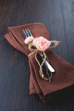 Tablo kahverengi peçete ile ayar ve gül.