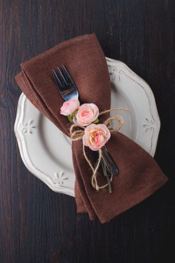 Tablo kahverengi peçete ile ayar ve gül.