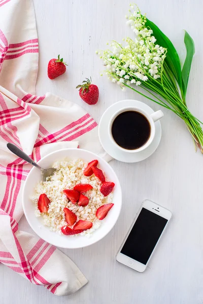 Telefone e xícara de café com prato de queijo cottage com palha — Fotografia de Stock