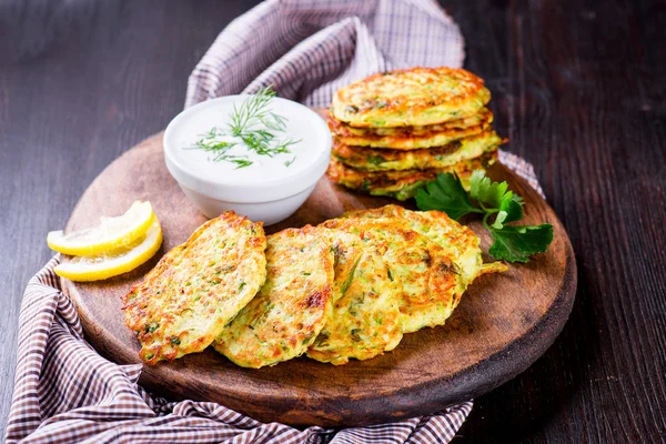 Beignets de courgettes aux herbes et feta sur la planche de bois — Photo