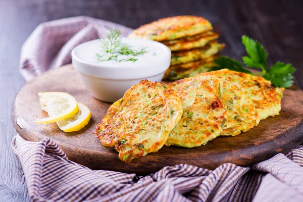 Beignets de courgettes aux herbes et feta sur la planche de bois — Photo