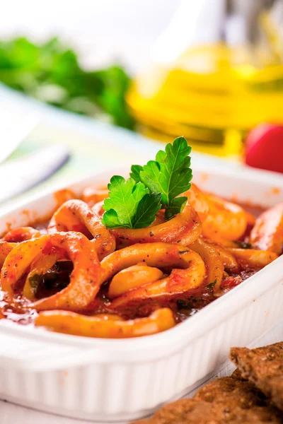 Stewed squid rings with tomato sauce in white plate Stock Picture