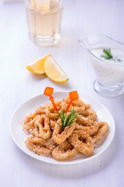 Kızarmış kalamar halkaları limon, otlar ve baharatlar