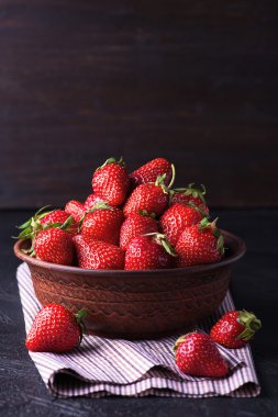 Karanlık tablo üzerinde kahverengi kase taze çilek
