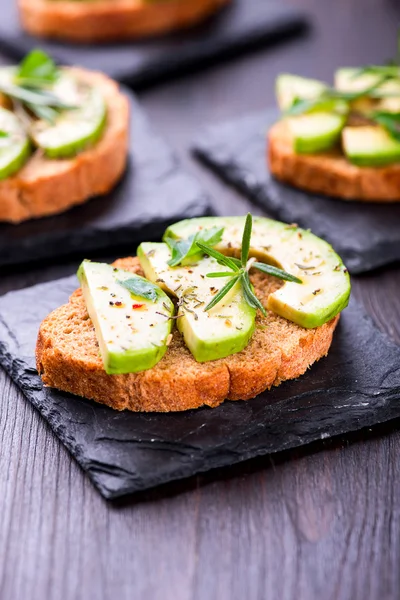 Toast with avocado, herbs on slate board — Stock Photo, Image
