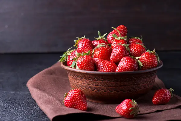 Fresh strawberry in the brown bowl on dark table — Stock Photo, Image