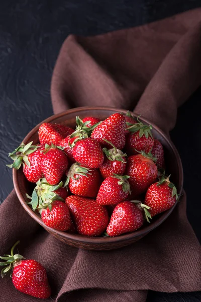 Fresh strawberry in the brown bowl on dark table — Stock Photo, Image