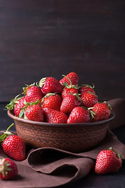 Fresh strawberry in the brown bowl on dark table — Stock Photo, Image