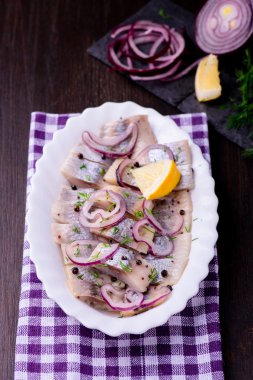 Ringa balığı salatası soğan ve otlar ve limon ile