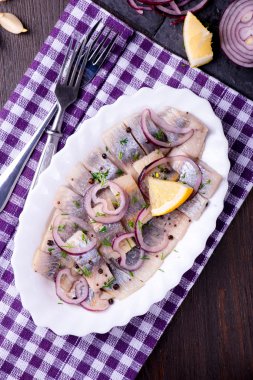 Ringa balığı salatası soğan ve otlar ve limon ile