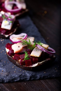 Sandviç ile ringa balığı ve pancar kayrak bir plaka üzerinde