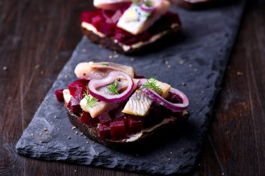 Sandviç ile ringa balığı ve pancar kayrak bir plaka üzerinde