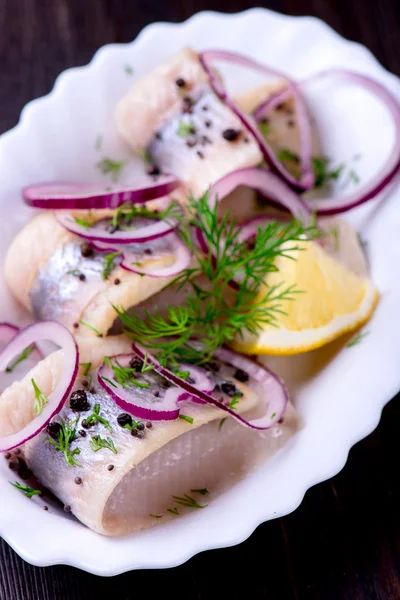 Sill med peppar, örter, salt och citron på vita keramiska plat — Stockfoto