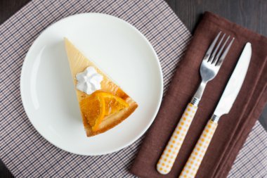 Cheesecake tatlı portakal ve beze dekore edilmiş