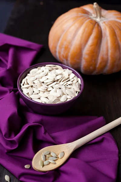 Bowl with toasted pumpkin seeds and pumpkins — Stock Photo, Image