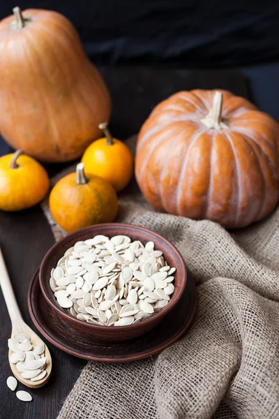 Bowl with toasted pumpkin seeds and wooden spoon — Stock Photo, Image