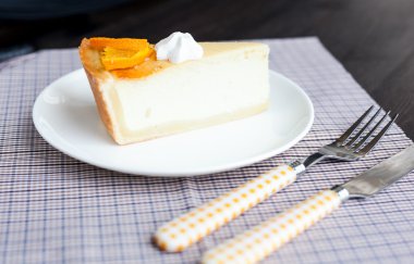 Cheesecake tatlı portakal ve beze dekore edilmiş