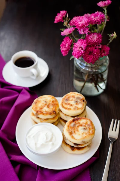 Heerlijke huisgemaakte kaas pannenkoeken met zwarte koffie — Stockfoto