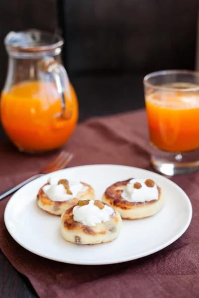 Deliciosos panqueques caseros de queso con jugo de zanahoria fresca —  Fotos de Stock