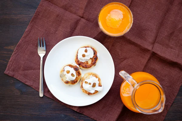 Heerlijke huisgemaakte kaas pannenkoeken met verse wortelsap — Stockfoto