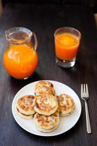 Heerlijke huisgemaakte kaas pannenkoeken met verse wortelsap — Stockfoto