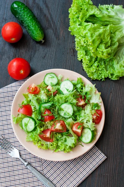 Tomato and cucumber salad with lettuce leafes — Stock Photo, Image