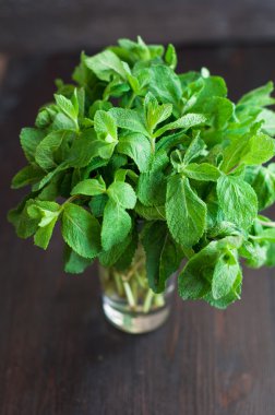 Tahta arka planda taze nane yaprakları