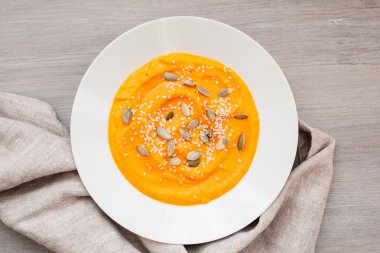 Beyaz bir tabak içinde tohumları ile kabak krem çorba