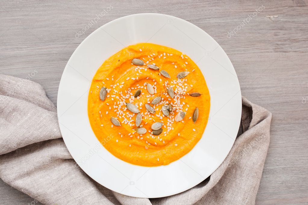 Pumpkin cream-soup with seeds in a white plate