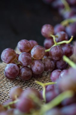 Ahşap masa üzerinde sepet üzüm demet